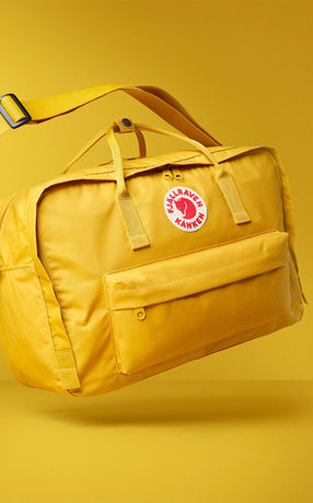 Fjällräven Kånken Weekender bag in vibrant yellow, blending iconic design with spacious functionality for travel and adventures.