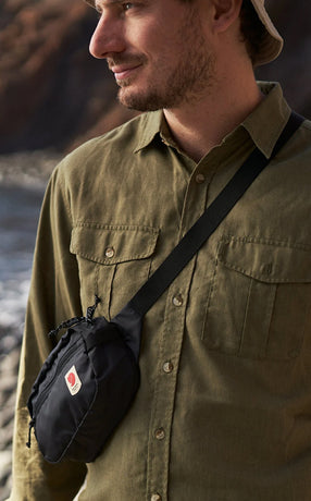 Man wearing a Fjällräven hip pack, highlighting compact and functional design ideal for travel and outdoor essentials.
