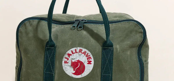 Classic green Fjällräven Kånken backpack isolated on a light background, showcasing its minimalist design