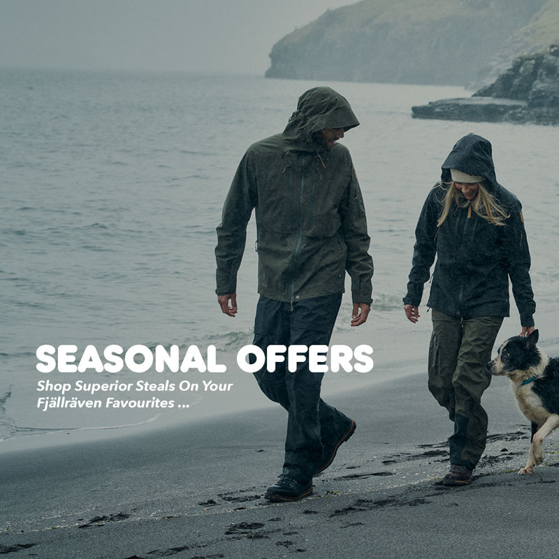 Two people and a dog walking on a beach in green Fjällräven jackets, with promotional text for seasonal offers on outdoor gear.