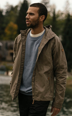 Man wearing a Fjällräven men's jacket in nature, highlighting durable outdoor wear designed for style and functionality.