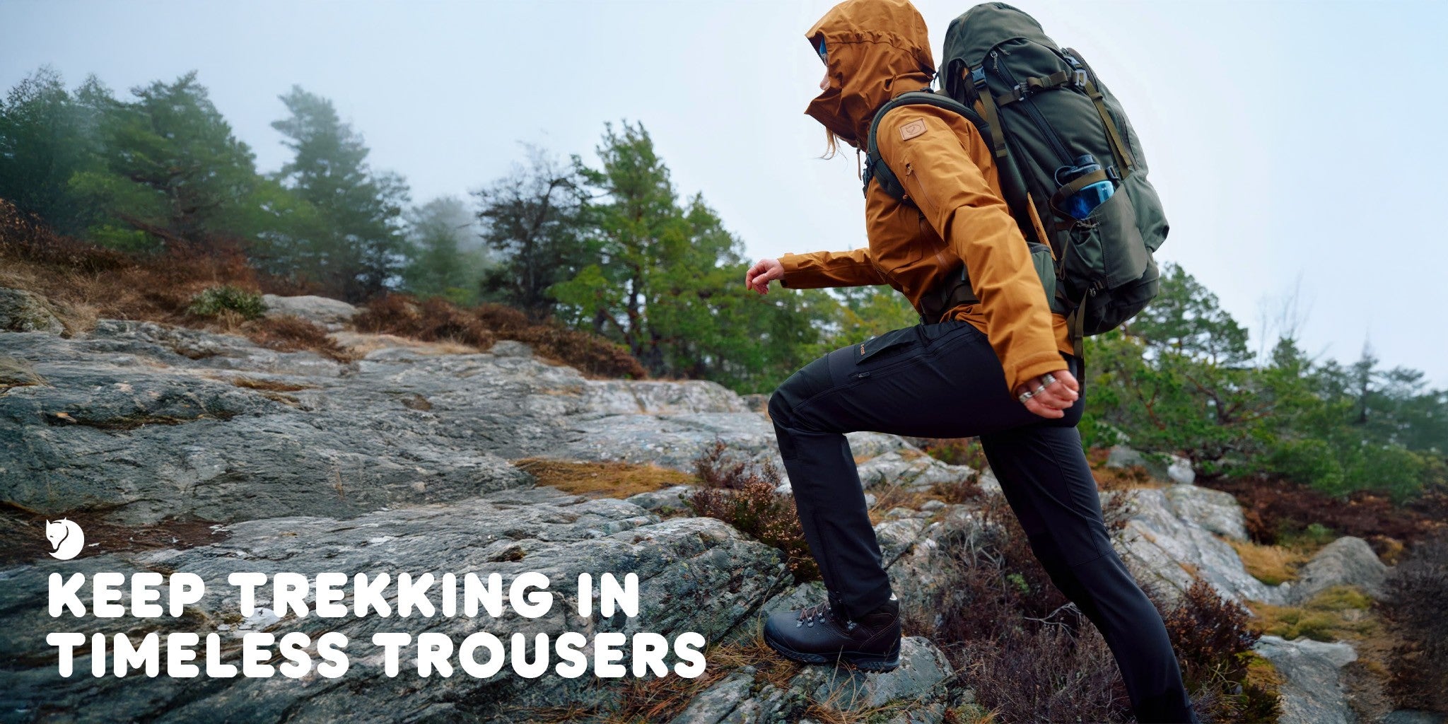 Person hiking on a rocky trail wearing Fjallraven trousers. Overlayed text 'Keep Trekking in Timeless Trousers'.
